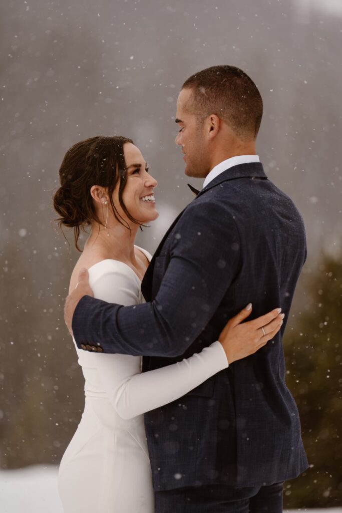 Bride and groom with snowflakes falling around them in June