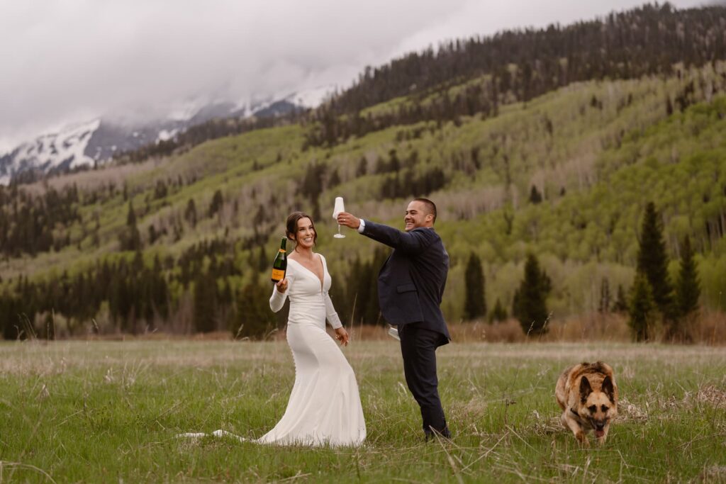 Couple pouring champagne before their wedding ceremony in the mountains of Colorado