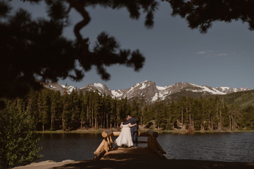 View of couple from the dock at Sprague Lake in Rocky Mountain National Park