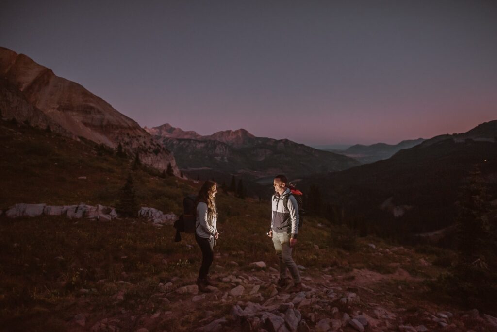 Couple hiking at sunrise in mountains of Telluride, Colorado on their wedding day
