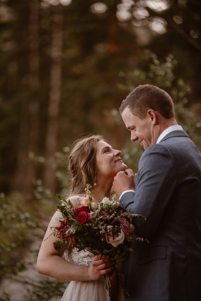 Couple hiking through the forest on their wedding day in CO