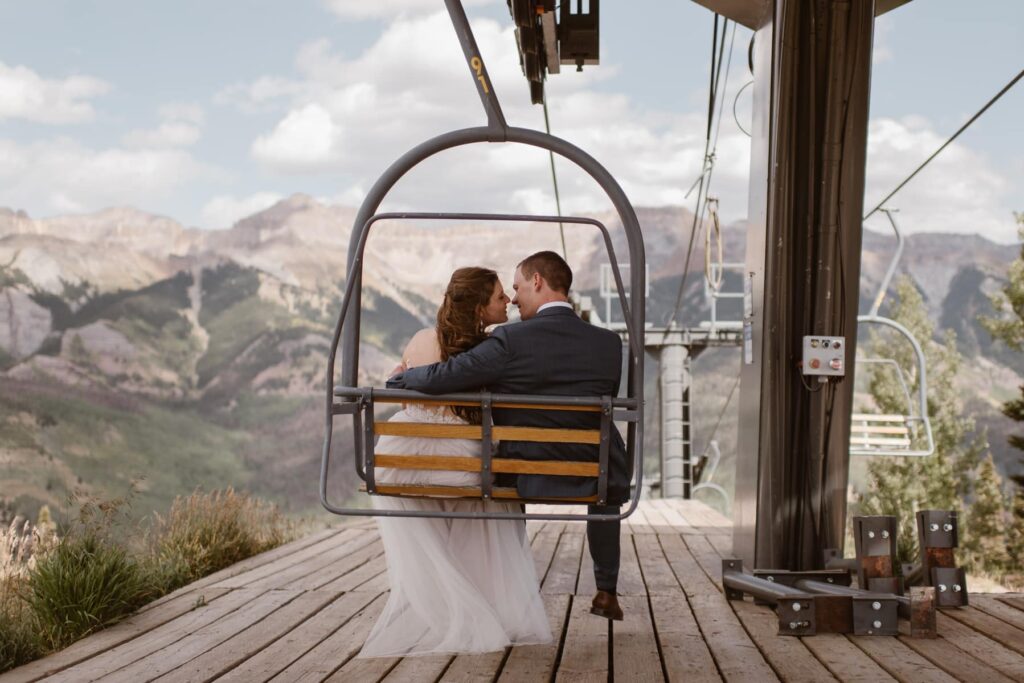 Bride and groom on ski lift in Telluride, Colorado