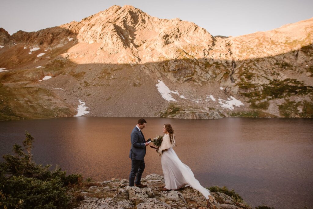 Sunrise wedding vow reading at a Colorado alpine lake 