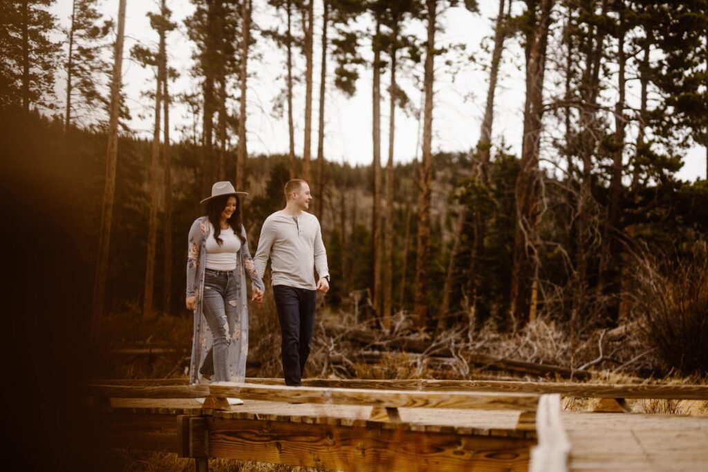 Couple walking down a boardwalk through a wooded area