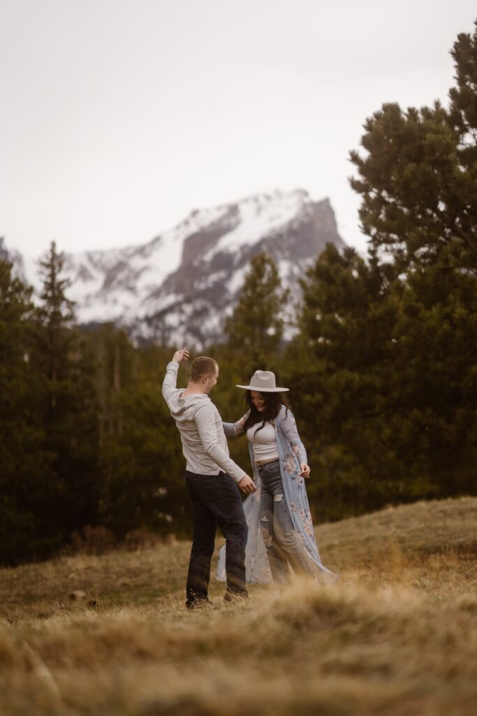 Couple dancing in a meadow near Sprague Lake during their engagement session