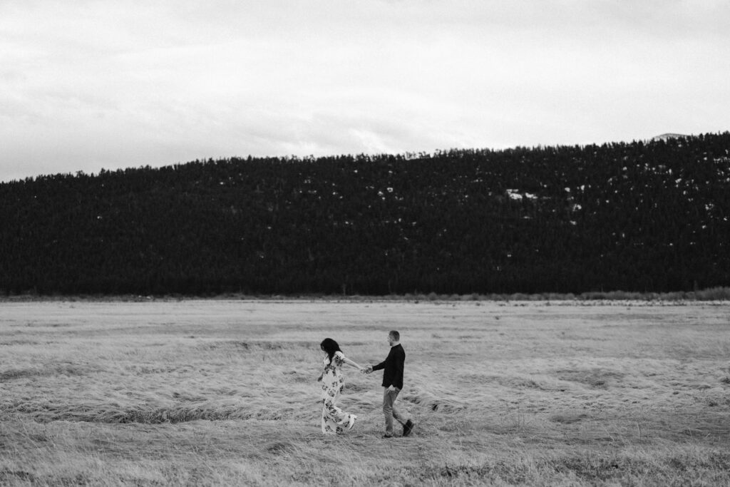 Couple walking through a mountain meadow in CO