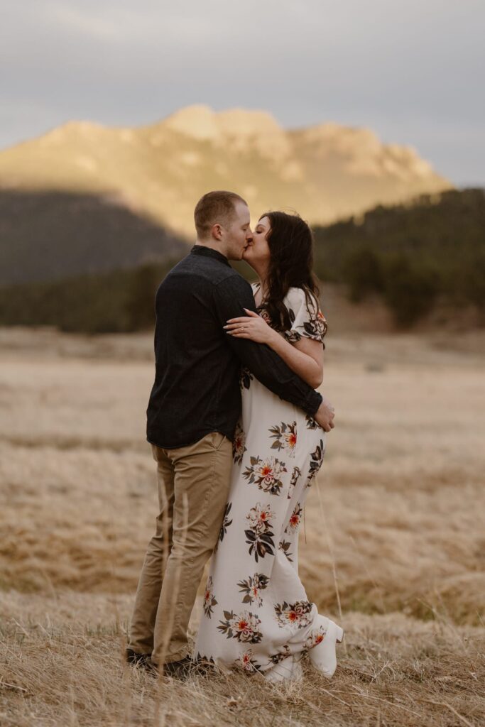 Couple kissing in a mountain meadow at sunset