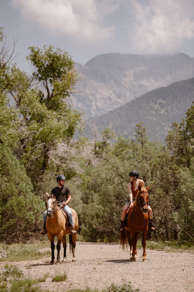 Couple horseback riding in the mountains 