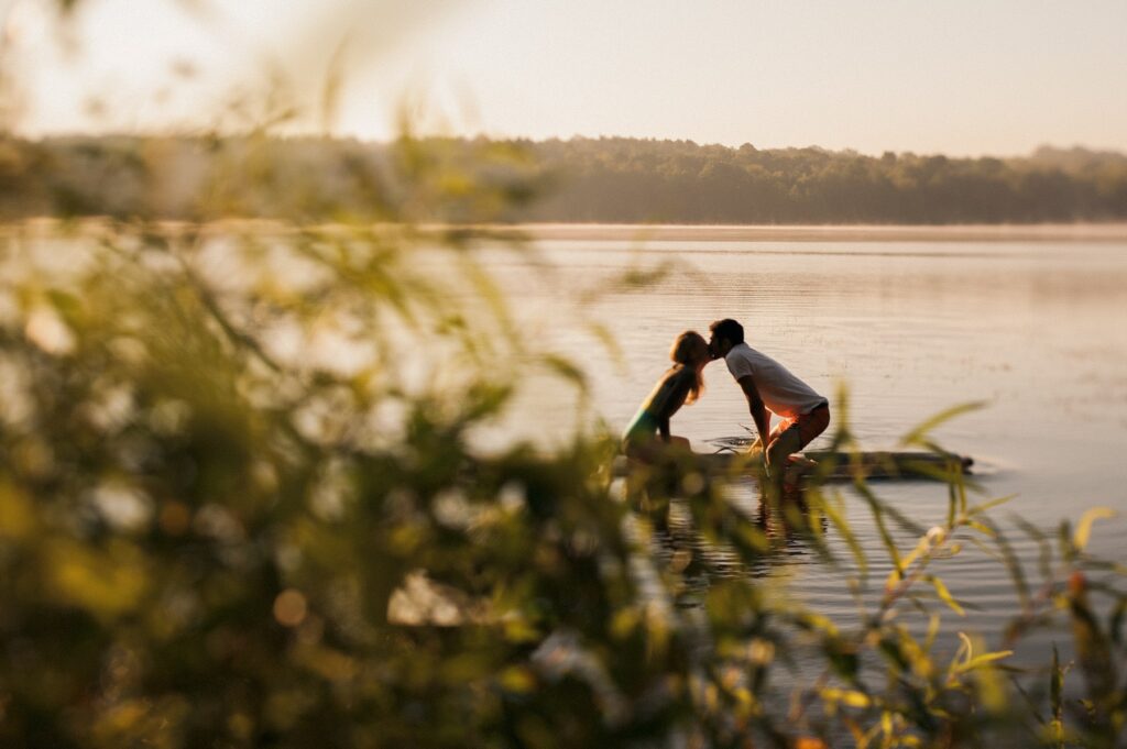 Couple kissing on paddleboards on a lake