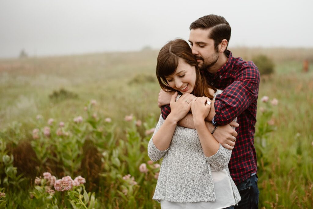 Couple in a foggy meadow in Colorado during engagement